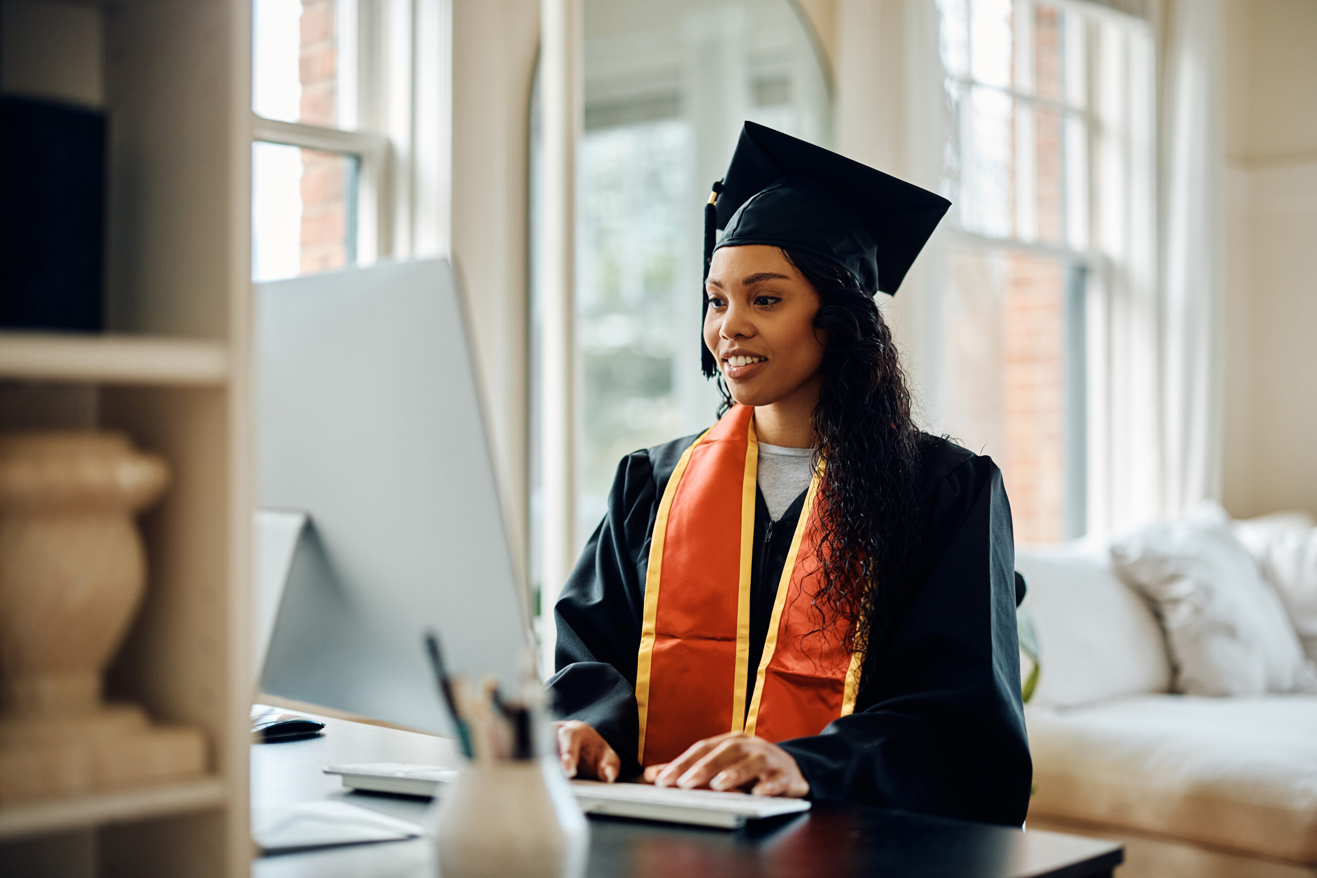 New graduate searching for a sales job using a computer.