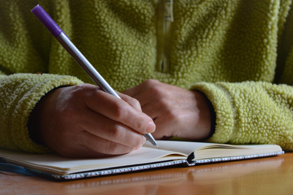 A person writing her career plan on a notebook.