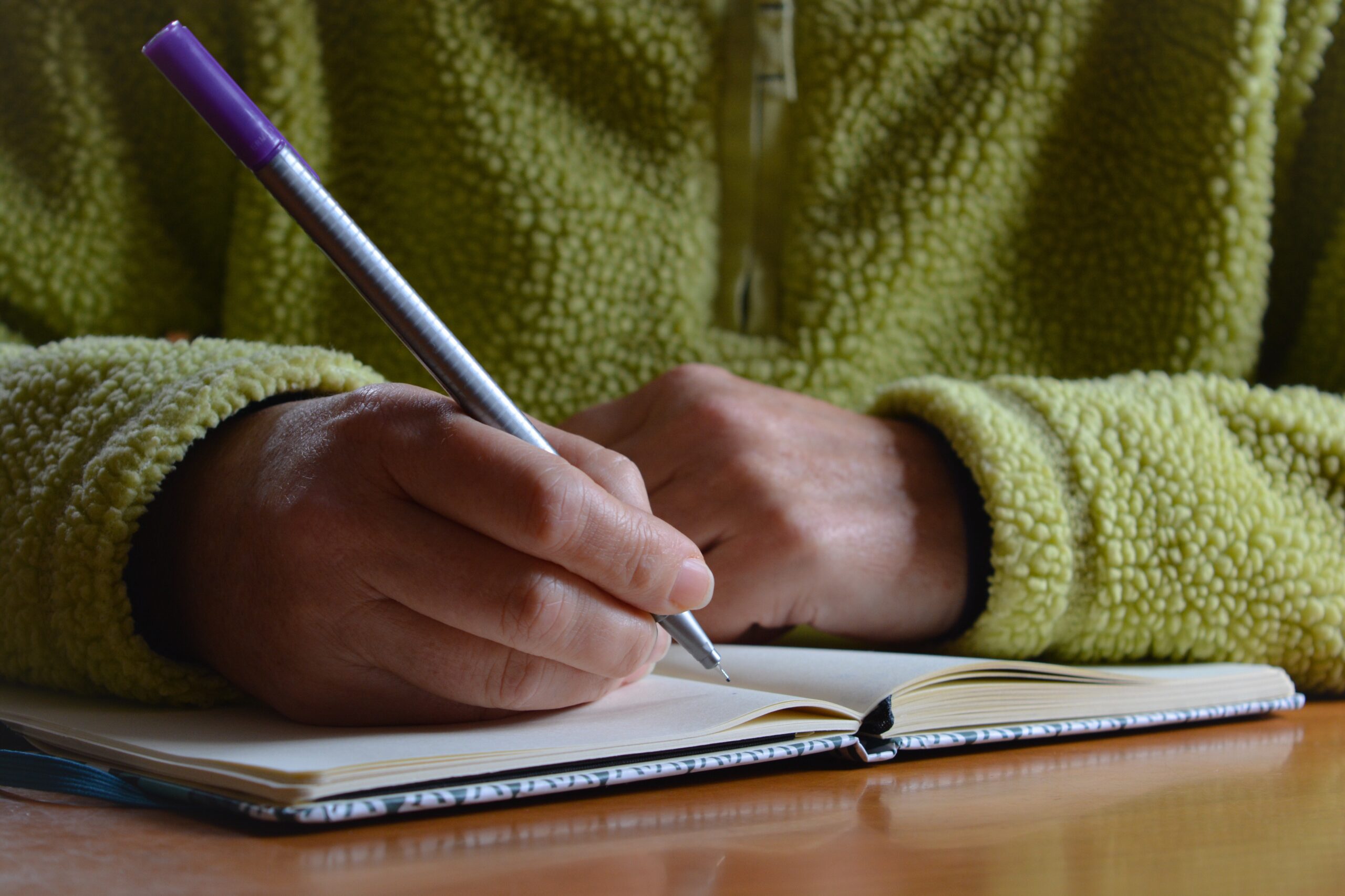 A person writing her career plan on a notebook.